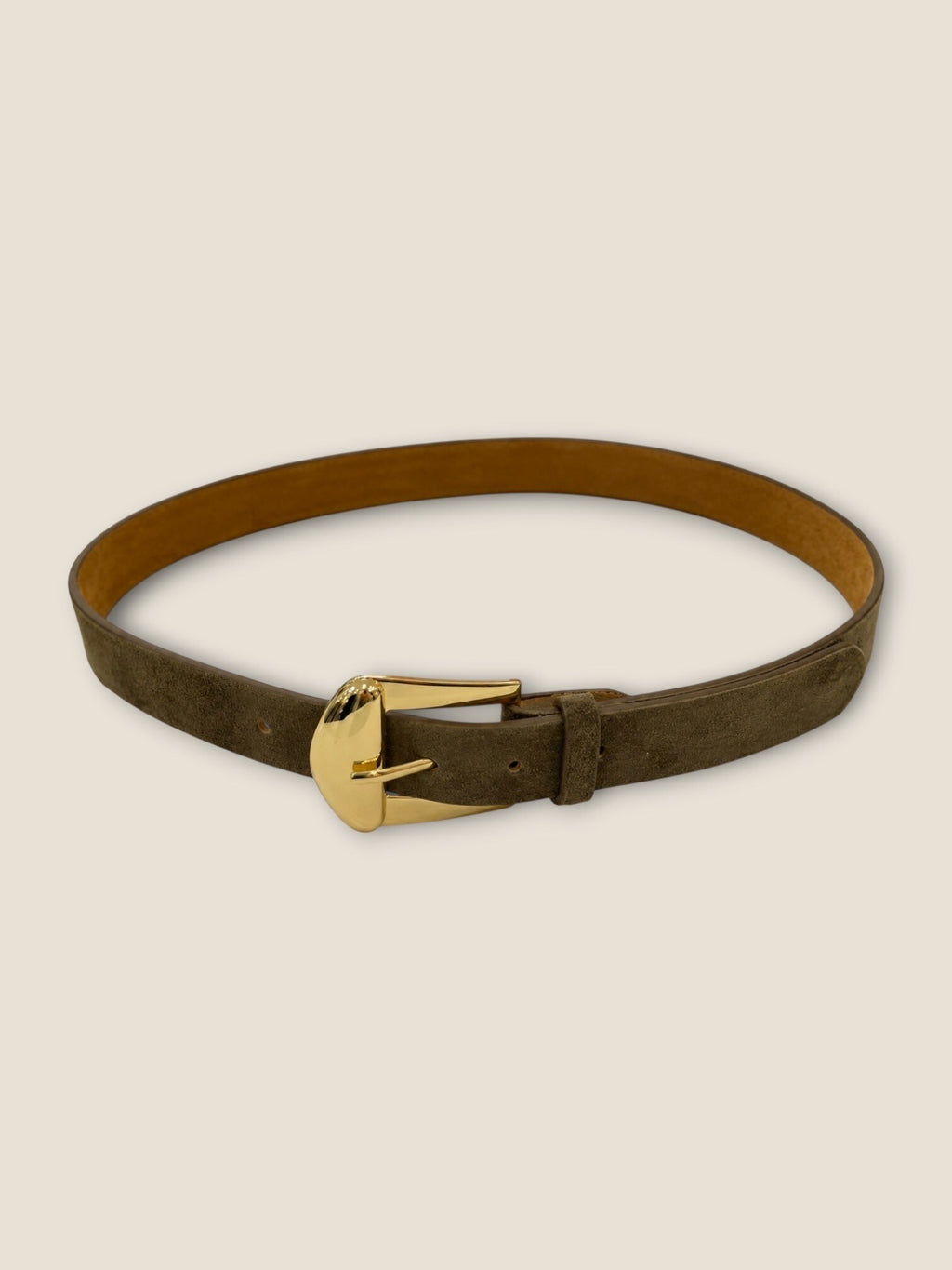 Ceinture fine en suédine kaki à boucle dorée portée sur un pantalon crème